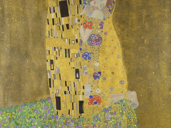 Couple wrapped in gilded robes embracing on a flowering meadow